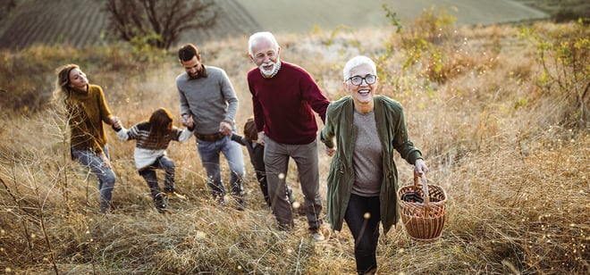 A multi-generational family hiking up a hill together.